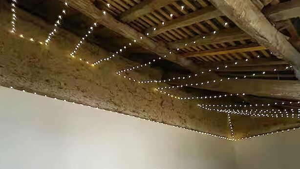 A hot tub with a wooden ceiling and string lights. - One Bedroom Home In Plouasne (Plouasne)