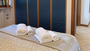 Un dormitorio con cama, armario y ventana.