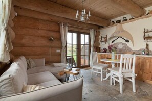 A log cabin interior with a sofa, dining table, chairs, and a kitchen area. - Comfortable apartment, 2 levels, close to beach (Ustronie Morskie)