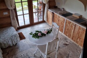 A cozy room with a round table, a white chair, and a floral centerpiece. - Comfortable apartment, 2 levels, close to beach (Ustronie Morskie)