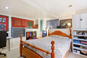 A bedroom with a wooden bed, a desk with a chair, and a wardrobe. - The Birdcage - Walk to CBD - Free Parking (West Hobart)