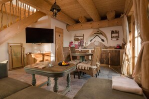 A cozy wooden interior with a dining area, a television mounted on the wall, and a staircase. - Comfortable apartment very close to the beach (Ustronie Morskie)