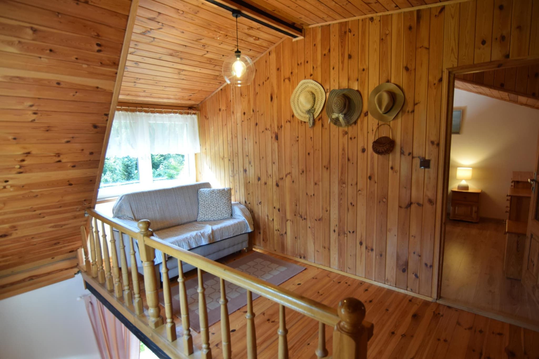 L’intérieur d’un chalet en bois comprend une chambre à coucher située en mezzanine, un balcon et un coin repas.