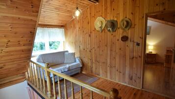 L’intérieur d’un chalet en bois comprend une chambre à coucher située en mezzanine, un balcon et un coin repas.