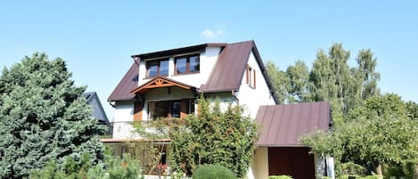 A two-story house with a sloped roof, a front porch, and a garage.