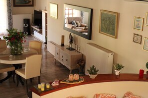 A living room with a dining area, a television, and a fireplace.