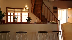 A kitchen with a wooden island, bar stools, and a staircase. - Gravanis Resort Luxury Villa with Private Pool in 30Acre Olive Grove near Athens (Sykamino)