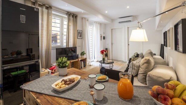 A modern living room with a dining area, a kitchen, and a TV. - Roncaglia, 27 - Comfort & Character (Milano)