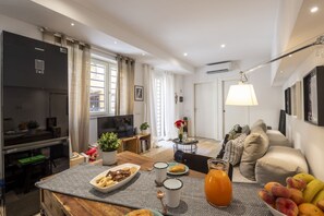 A modern living room with a dining area, a kitchen, and a TV. - Roncaglia, 27 - Comfort & Character (Milano)
