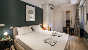 A hotel room with a bed, a framed map, a desk with a lamp, and a window with curtains. - Roncaglia, 27 - Comfort & Character (Milano)
