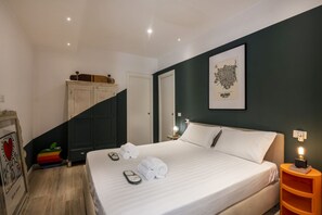 A bedroom with a bed, a nightstand, a dresser, a framed picture, and a staircase. - Roncaglia, 27 - Comfort & Character (Milano)