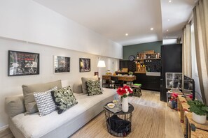 Ein modernes Wohnzimmer mit Sofa, Couchtisch und Kunstwerken an den Wänden.