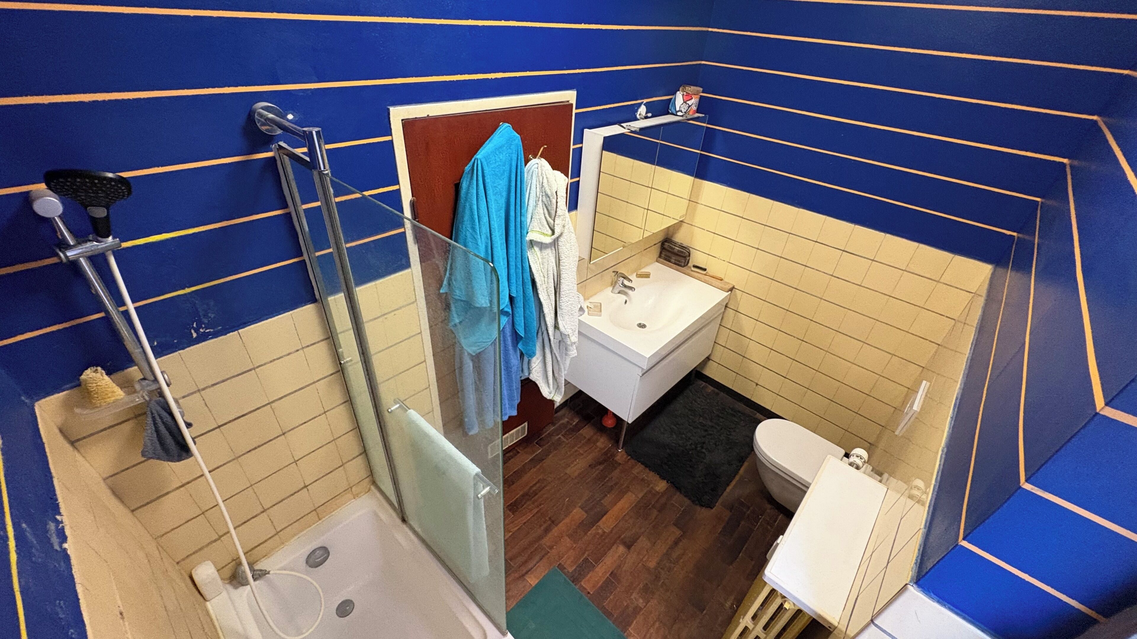 A compact bathroom with a shower, sink, and toilet.