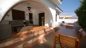 A covered outdoor seating area with a sofa, chairs, and a table. - SAONA VILLAS (VN FARNO): villa sleeps 6, private pool, wifi, air-conditioning (Les Tres Cales)