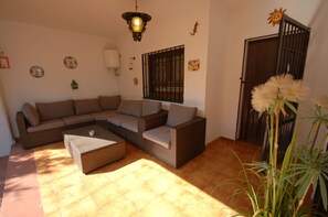 Uma sala de estar com sofá em seção, mesa de centro e luminária pendente.