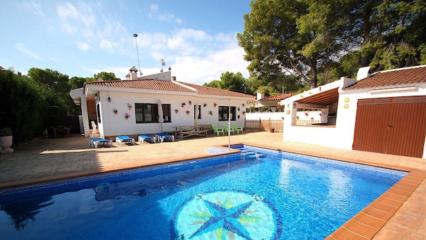 A swimming pool with a star pattern, a white building with a red roof, and a wooden fence. - SAONA VILLAS (VN FARNO): villa sleeps 6, private pool, wifi, air-conditioning (Les Tres Cales)
