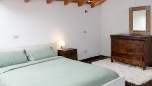 A bedroom with a bed, a dresser, a mirror, and a nightstand. - Coconut House (Alzano Lombardo)