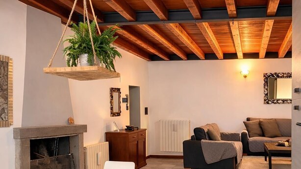 A modern interior with a dining area, a fireplace, and a living space. - Coconut House (Alzano Lombardo)