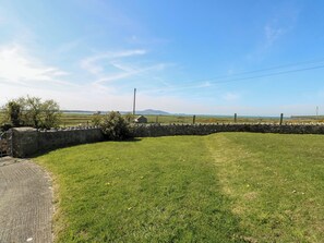 Ländliche Landschaft mit Steinmauer, Wiesen und weitläufigen Hügeln.