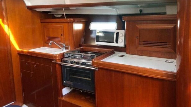 Una cocina compacta con estufa, microondas y armarios de madera.