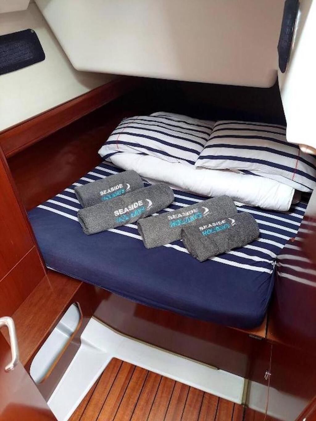 Une petite cabine équipée d’un lit, d’oreillers et d’une paire de chaussons.
