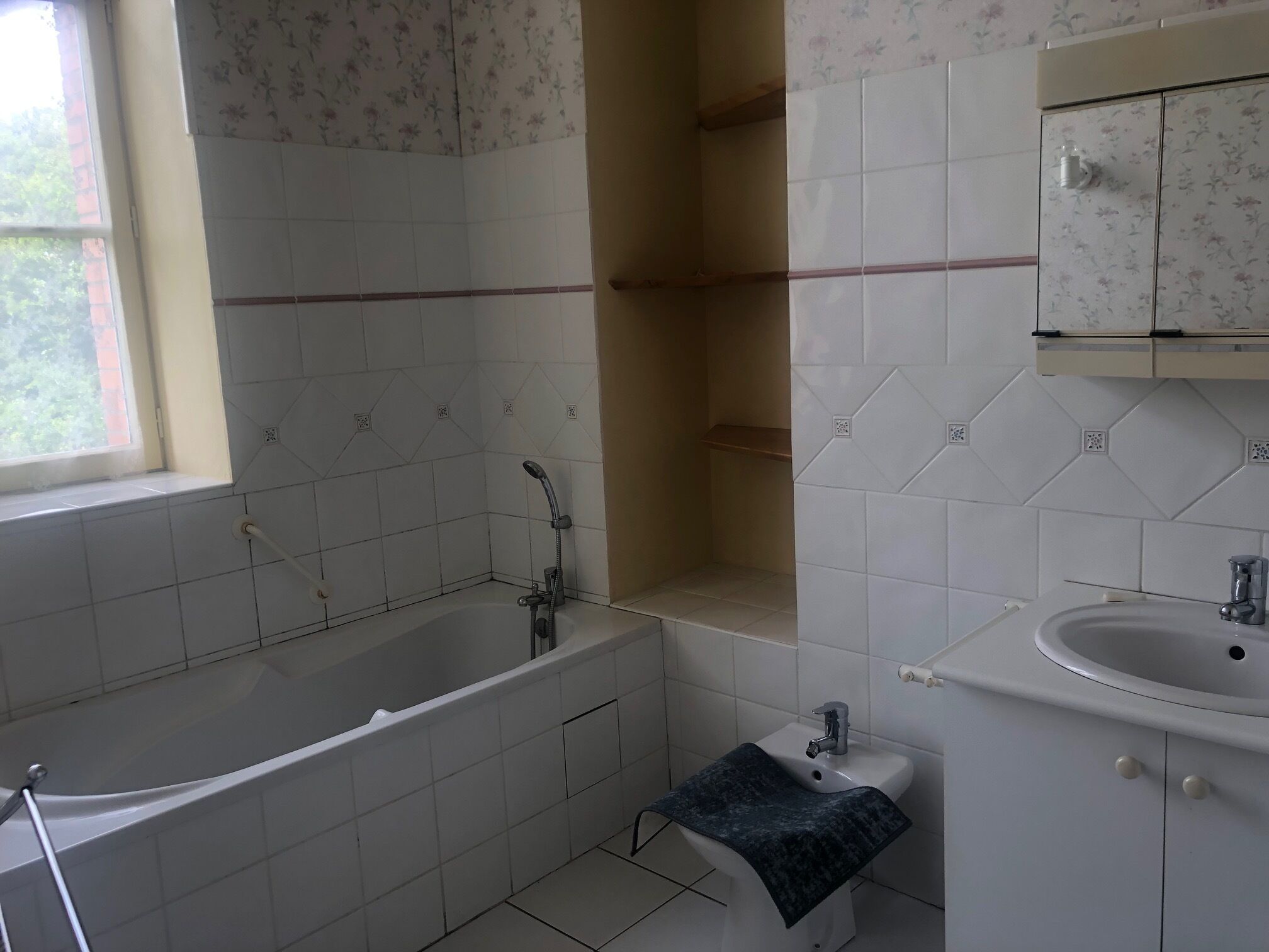 Ein Badezimmer mit Badewanne, Waschbecken und Fenster.