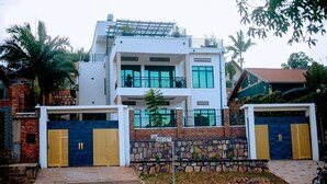 A modern two-story house with a stone facade, a balcony, and a gated entrance. - Juru House Rentals  (Kigali)