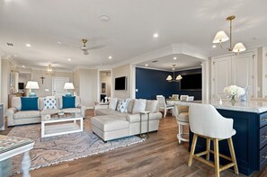 A modern living room with a sofa, coffee table, and a dining area with chairs and a table. - 103 Turtle Lane at The Sea Pines Resort (Hilton Head Island)