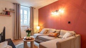 Ein gemütliches Wohnzimmer mit einer Couch, einem Couchtisch, einer Lampe und einem Bücherregal.