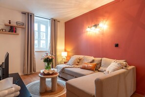 A cozy living room with a sofa, a coffee table, a lamp, and a bookshelf. - Le Cocon Vannetais - 300m du Port de Vannes (Vannes)
