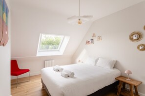 A bedroom with a bed, a red chair, a bedside table, a lamp, and a window. - La Perle d'Arzon - Maison familiale en bord de mer (Arzon)