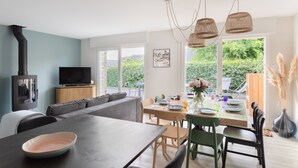 A modern living room with a sofa, dining table, and TV. - La Perle d'Arzon - Maison familiale en bord de mer (Arzon)