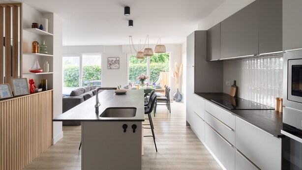 A modern kitchen with a central island, built-in appliances, and a dining area with a view. - La Perle d'Arzon - Maison familiale en bord de mer (Arzon)