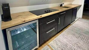 A modern kitchen with a built-in stove, a coffee maker, and a refrigerator. - Private Barn Loft w/ King Bed | Cozy Forest Escape (Parry Sound)