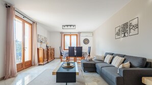 Un saló amb un sofà, una taula baixa i una zona de dinar amb cadires i taula.