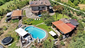 A residential property with a swimming pool, a covered patio, and a detached garage. - Villa Aresini – Exclusive Residence (Montemiletto)
