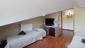 A bedroom with a bed, a desk, a television, and a fan. - Villa Aresini – Exclusive Residence (Montemiletto)