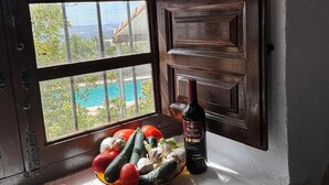 Aussicht auf Pool und Berge, eine Weinflasche und eine Obstschale.