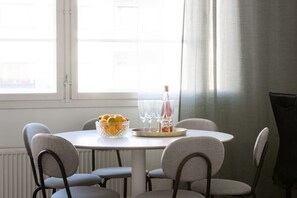 Ruokapöytä tuoleineen, hedelmäkulho ja pullo väkevää alkoholijuomaa.