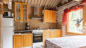 Une cuisine rustique avec des meubles en bois, un poêle et une fenêtre donnant sur un paysage agréable.
