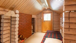 Une chambre de style rustique, avec un lit, un plafond en bois et une fenêtre.