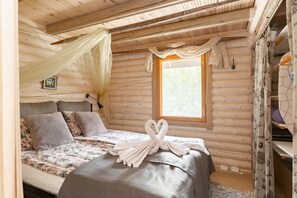Un dormitorio rústico de cabaña con una cama, una ventana y un arreglo decorativo de toallas.