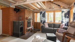 Un salon chaleureux avec une cheminée, un canapé et un plafond en bois.