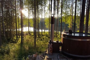 Kuumavesiallas metsässä, josta avautuu näkymä järvelle.