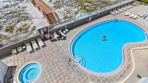 Ein großer Pool im Freien mit Holzterrasse, Liegestühlen und einem kleinen kreisförmigen Pool.