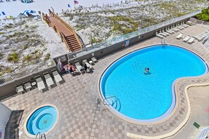 Ein großer Pool im Freien mit Holzterrasse, Liegestühlen und einem kleinen kreisförmigen Pool.