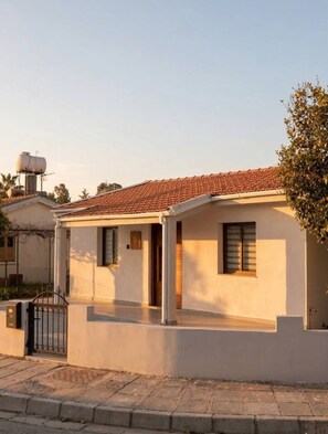 A single-story house with a tiled roof, a water tank on the roof, and a small porch area. - TelMar Kiti Escape House (Kiti)