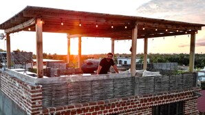 A rooftop bar with a wooden pergola, brick walls, and string lights. - TS4 King in Todos Santos (Todos Santos)
