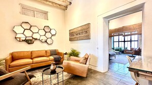Ein Wohnzimmer mit Sofa, Sessel, Couchtisch und Wandkunst.
