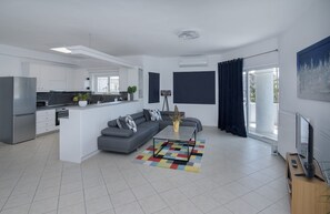 A modern apartment with a kitchen, living area, and balcony. - Angel Apartment at Amoudara (Malevizi)